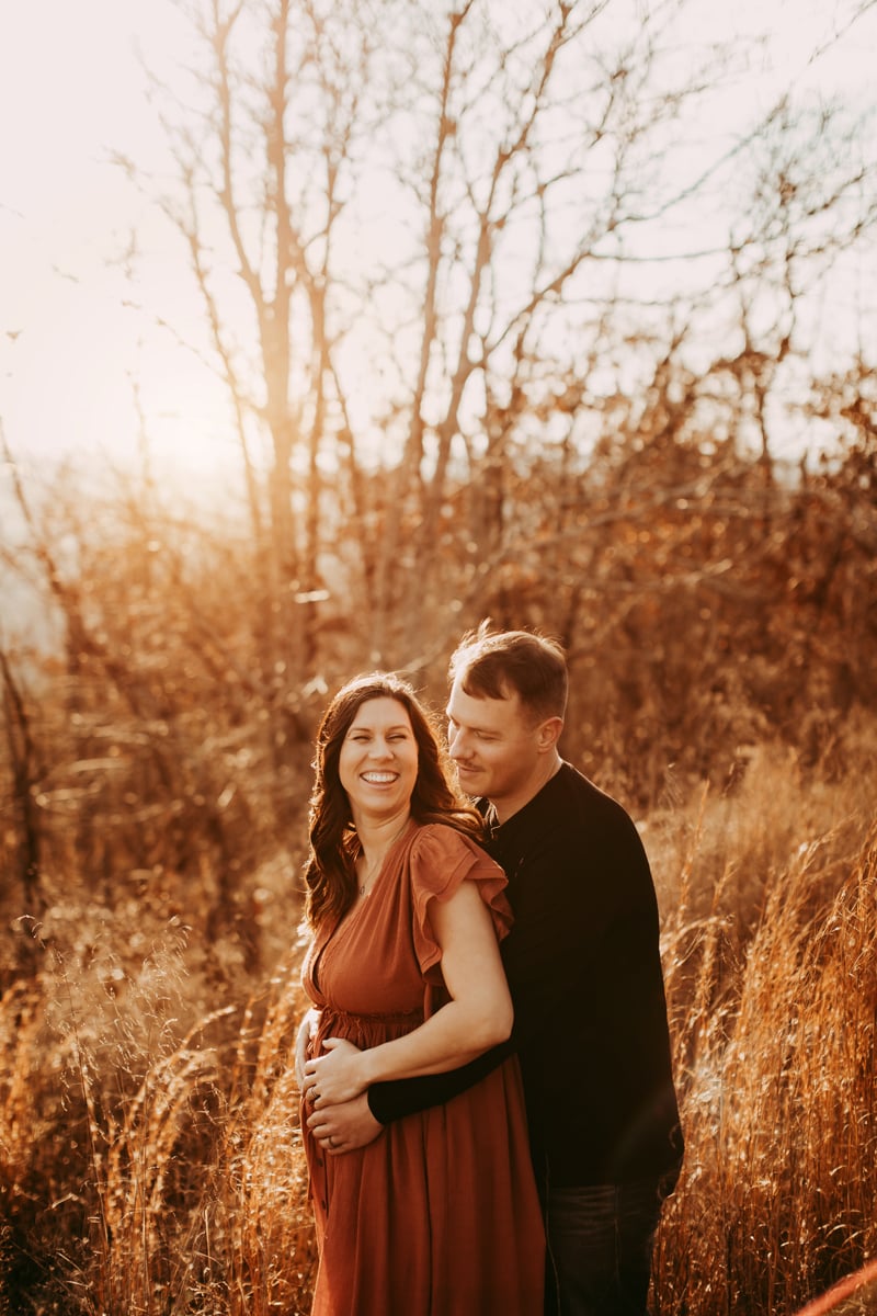 golden hour maternity - couple laughing and smiling on overlook